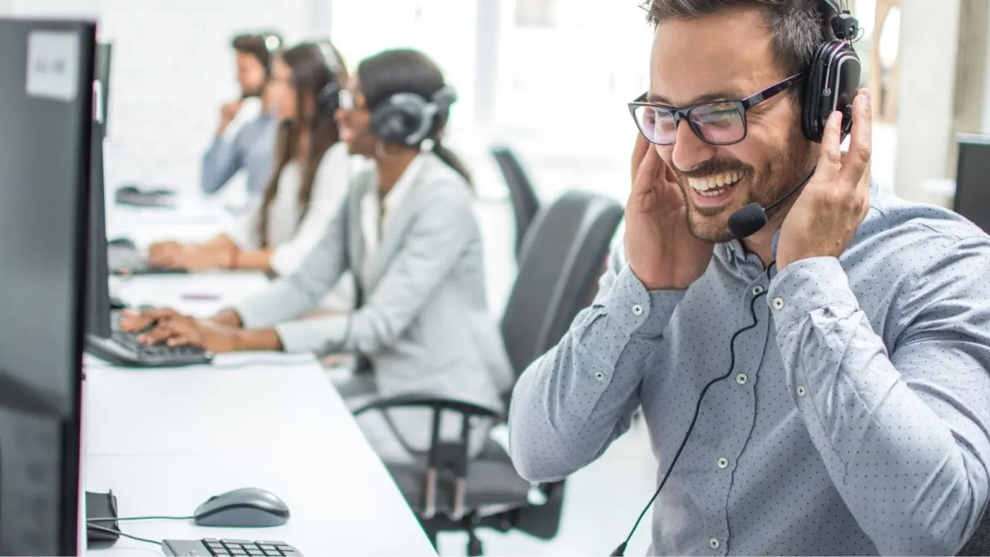 Un hombre habla por teléfono en la oficina con auriculares.