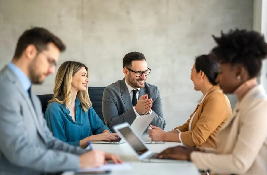 Un hombre expresa su satisfacción y agradecimiento a su equipo durante una reunión.