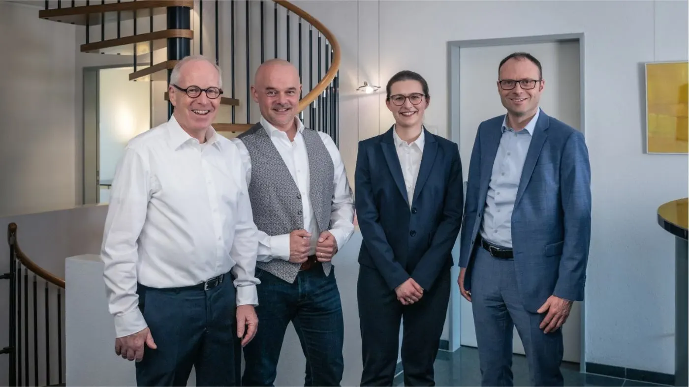 Gruppenbild des future-cube-Teams vor der Wendeltreppe in ihrem Büro.